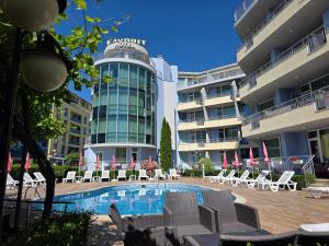 a hotel with a swimming pool in front of a building at Favorit Aparthotel in Sunny Beach