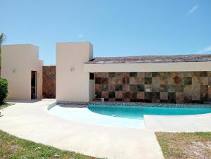 a villa with a swimming pool and a house at Villas Aakal Petirojo in Chicxulub