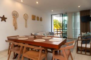 a dining room with a wooden table and chairs at Villas Aakal Petirojo in Chicxulub