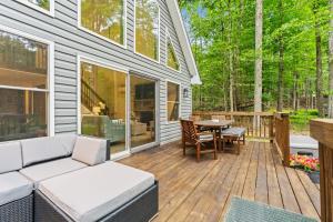 a deck with a couch and a table on a house at Brand New Chalet - Seclusion Arcadez Fire Pit in Locust Lakes Village