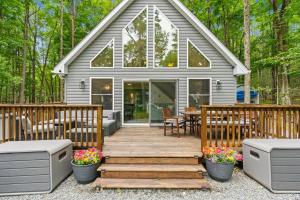 a tiny house with a wooden deck in the woods at Brand New Chalet - Seclusion Arcadez Fire Pit in Locust Lakes Village