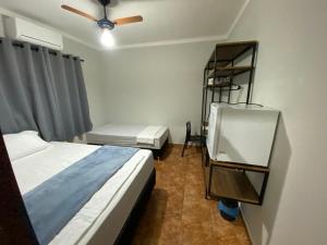 a bedroom with two beds and a ceiling fan at Harmony House Hospedagem in Votuporanga +18 photos
