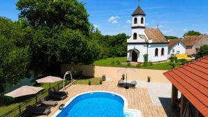 a building with a church and a swimming pool with a church at River House Batrovci in Batrovci