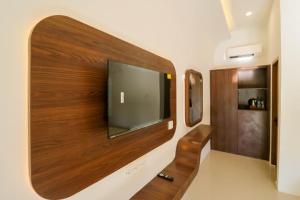 a flat screen tv on a wall in a room at Mina Tanjung Hotel in Tanjung
