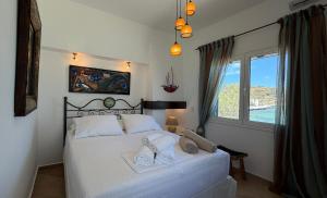 a bedroom with a white bed with towels on it at Almira Prassa Beach House Kimolos in Prasonísi