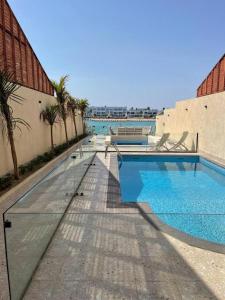 a large swimming pool next to a building at 12 Durrat Al Arous - Rose Beach Villas in Durat Alarous