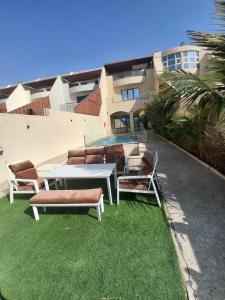 a group of chairs and a table on the grass at 12 Durrat Al Arous - Rose Beach Villas in Durat Alarous