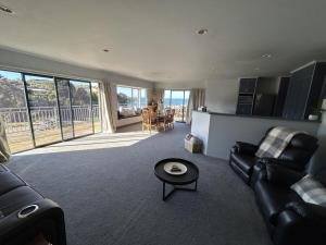 a living room with a couch and a table at Seaside At Stephens Bay in Kaiteriteri