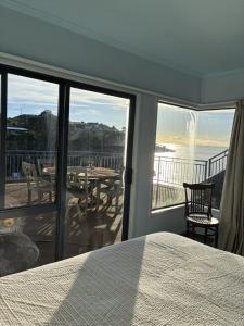 a bedroom with a bed and a view of the ocean at Seaside At Stephens Bay in Kaiteriteri