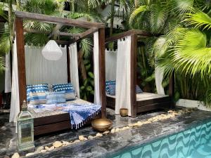 a bed with blue and white pillows next to a pool at Tribal Hotel in Granada