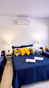 a bedroom with two beds with blue and yellow pillows at São Gabriel Centro Studios & Suítes in São Gabriel