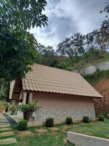 a house with a tile roof on a yard at Chalé Sognare Due in Santa Teresa