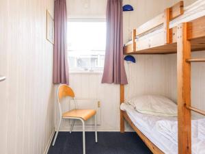 a small room with a bunk bed and a chair at 10 person holiday home in Ørsted in Ørsted +27 photos