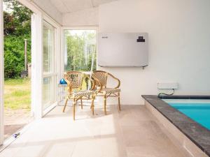 two chairs and a table next to a swimming pool at 10 person holiday home in Ørsted in Ørsted