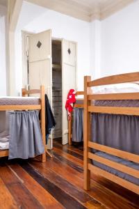 two bunk beds in a room with wooden floors at Rio Vibes Hostel - Hostel na Glória, AC, Social Vibe & Próximo a Lapa in Rio de Janeiro