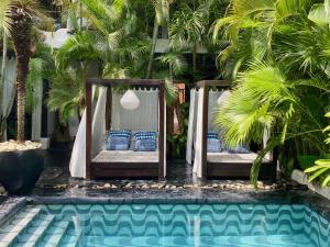 two beds in front of a pool with palm trees at Tribal Hotel in Granada +18 photos