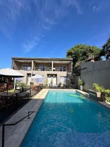 a large swimming pool in front of a house at Los Lirios Apart & Suite in Puerto Iguazú