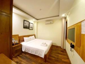 a bedroom with a white bed and a television at Senkotel Nha Trang Managed by NEST Group in Nha Trang +58 photos