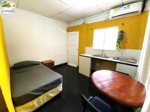 a room with a bed and a desk and a table at Posada Nativa Trinsan Centro in San Andrés