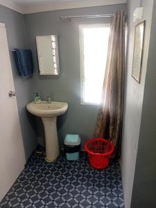 a small bathroom with a sink and a window at Home Away From Home in Nadi +6 photos
