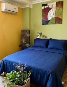 a bedroom with a blue bed with a blue bedspread at Posada Doña Alcinda in Catia La Mar