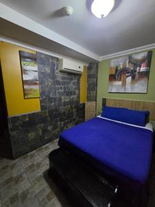 a bedroom with a blue bed in a room at Posada Doña Alcinda in Catia La Mar