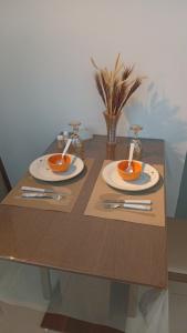 a wooden table with two plates and silverware on it at Studio Premium Trianon Centro in Campos dos Goytacazes