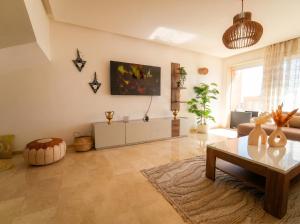 a living room with a table and a couch at Ocean View Duplex & Golf, Taghazout Bay in Tamraght Ouzdar