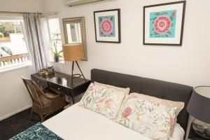 a bedroom with a bed and a table and a desk at Nyima Tashi Buddhist Centre in Auckland
