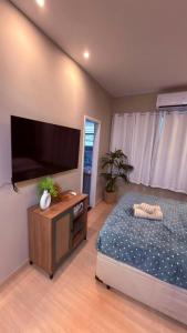 a bedroom with a bed and a flat screen tv at Studio no Centro do Rio l Próximo ao Metrô e VLT in Rio de Janeiro