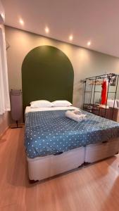 a bedroom with a large bed with a green headboard at Studio no Centro do Rio l Próximo ao Metrô e VLT in Rio de Janeiro