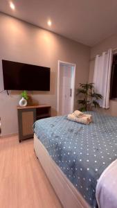 a bedroom with a bed and a flat screen tv at Studio no Centro do Rio l Próximo ao Metrô e VLT in Rio de Janeiro