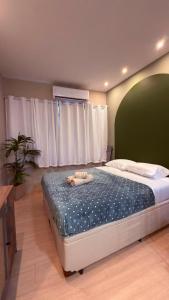 a bedroom with a large bed with a green headboard at Studio no Centro do Rio l Próximo ao Metrô e VLT in Rio de Janeiro