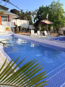 a blue swimming pool with chairs and a umbrella at La Casa di Giovanna in Alfonso