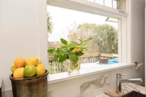 a window with a bowl of fruit on a window sill at Nyima Tashi Buddhist Centre in Auckland
