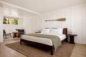 a bedroom with a large bed with white walls at The Herondale Hotel in Astoria, Oregon