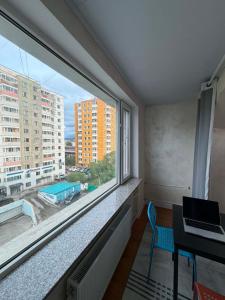a room with a window and a laptop on a desk at GG Hostel MONGOLIA 지지호스텔 몽골 in Ulaanbaatar