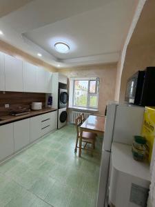 a kitchen with white cabinets and a table in it at GG Hostel MONGOLIA 지지호스텔 몽골 in Ulaanbaatar