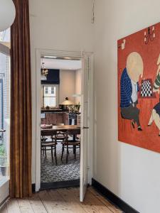 a kitchen and dining room with a painting on the wall at Romantische kamer nabij centrum in Eindhoven