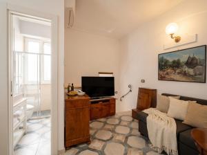 a living room with a couch and a flat screen tv at Dimora BoxFish - Panorama terrace in Polignano a Mare