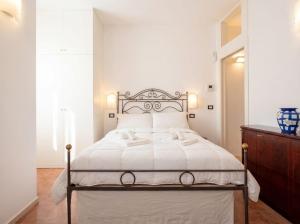 a bedroom with a white bed with a metal headboard at Dimora BoxFish - Panorama terrace in Polignano a Mare