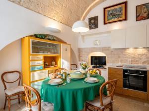 a kitchen with a table with a green table cloth at Dimora BoxFish - Panorama terrace in Polignano a Mare
