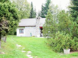 een wit bakstenen huis met een tuin en bomen bij Spacious chalet in Randogne near Crans Montana in Randogne