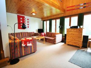 een woonkamer met een bank en een tafel bij Spacious chalet in Randogne near Crans Montana in Randogne