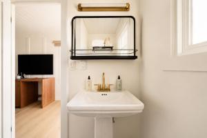 a bathroom with a white sink and a mirror at The Herondale Hotel in Astoria, Oregon +47 photos