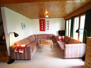 een woonkamer met 2 banken en een tafel bij Spacious chalet in Randogne near Crans Montana in Randogne
