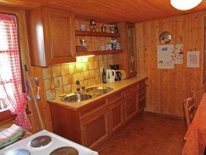 a small kitchen with a sink and wooden cabinets at Boutique Apartment in Valais with Balcony in Guttet-Feschel