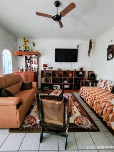 a living room with a couch and a flat screen tv at CASA com ACOMODAÇÃO para 6 PESSOAS in Guaratinguetá