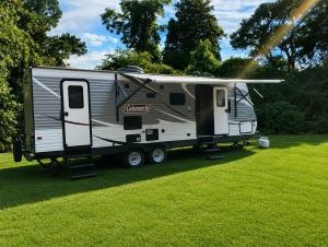 an rv is parked in a field with a sprinkler at Camper Rental in Saint Helena Island
