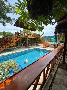 a swimming pool with a wooden bench next to a building at Cabañas Sol y Mar in San Antero +1 photo